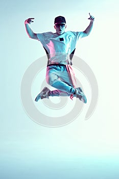 Breakdancer young man floating in the air in a jump in neon light. Dance school poster. Battle competition announcement