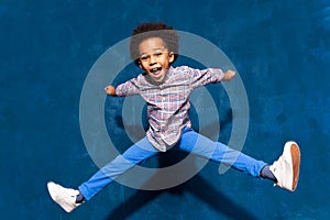 Breakdancing joyful african american cute little child boy levitating in jump.