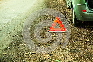 Breakdown of car. Red warning triangle sign on road