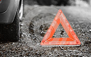 Breakdown of car. Red warning triangle sign on road