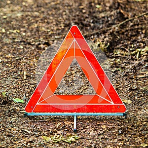 Breakdown of car. Red warning triangle sign on road