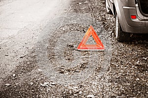 Breakdown of car. Red warning triangle sign on road