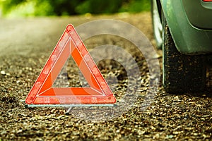 Breakdown of car. Red warning triangle sign on road