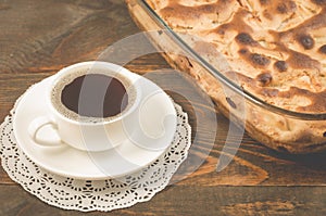 breakfast with apple pie and a cup of black coffee/ fresh pie and cup of fragrant black coffee on a wooden table. Selective focus