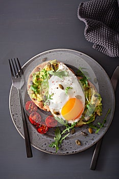Breakfast avocado sandwich with fried egg and tomato