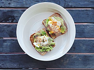 Breakfast: avocado toast with poached egg and chili flakes