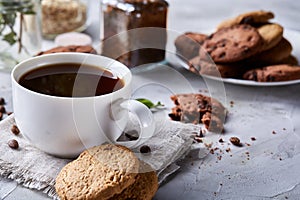 Breakfast background with mug of fresh coffee, homemade oatmeal cookies, grind coffee