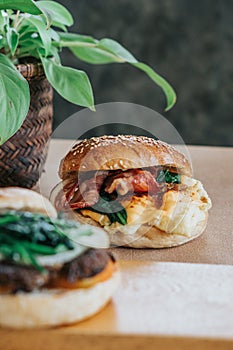 A breakfast bagel sandwich with scrambled eggs, spinach, and cheese on a plate