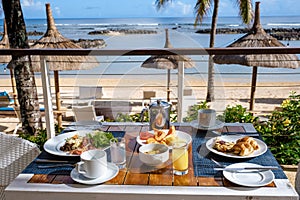 breakfast at a beach with palm trees and pool in Mauritius, tropical setting with breakfast