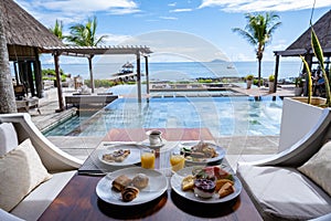 breakfast at a beach with palm trees and pool in Mauritius, tropical setting with breakfast