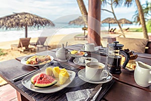 Breakfast on beach in Sri Lanka. Table setting with vegan food and coffee in restaurant outdoor