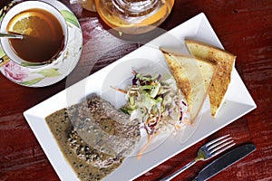 Breakfast with beafsteak, bread, vegetable and tea