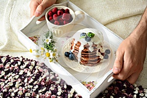 Breakfast in bed: chocolate pancakes with yogurt sauce and berries