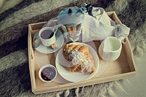 Breakfast in bed - coffee, croissant, milk on tray