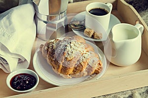 Breakfast in bed - coffee, croissant, milk on tray