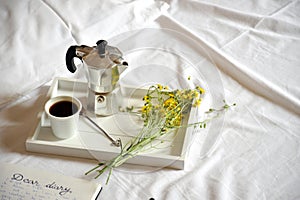 Breakfast in bed with coffee and diary on a lazy Sunday