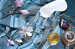 Breakfast in bed flat lay with magnolia flowers and green tea with marshmallows. Tea break concept.