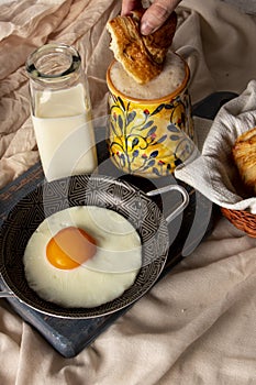 Fried egg with bread and coffee with milk