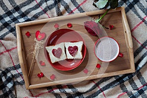 Breakfast in bed for Valentines Day. Romantic present with rose flower, toasts and hot chocolate. Top view.