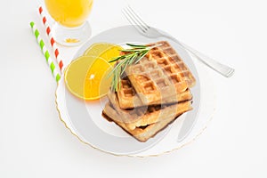 Breakfast with belgium waffles with rosemary and orange slices. Closeup view