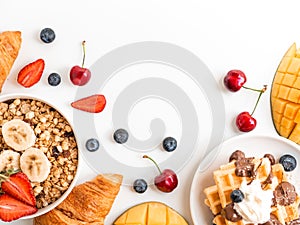 Breakfast berries and oatmeal frame with copy space. Waffle with mango, croissant and cherries. Flat lay top view