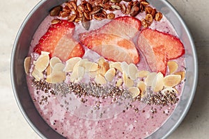 Breakfast berry smoothie bowl with chia seeds, oatmeal, almonds and strawberries. Healthy detox eating concept.