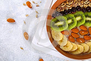 Breakfast berry smoothie bowl topped with bananas, berries, kiwi