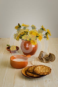 Breakfast with biscuits, fermented baked milk, a bouquet of dandelions