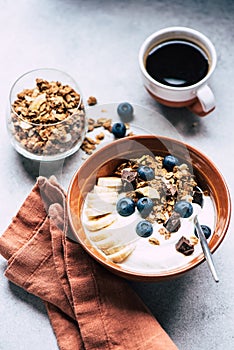 Breakfast bowl of yogurt with chocolate granola, blueberries and banana