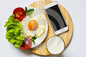 Breakfast with bread, fried eggs, milk and vegetables and fried tomato pieces isolated on white background.