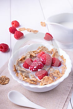 Breakfast with brown rice flakes, milk and fresh raspberries