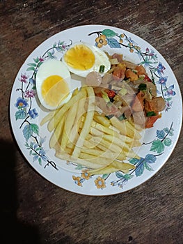 Breakfast or brunch with eggs, fries and sauted sausages