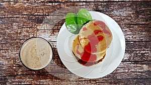 Breakfast with cappuccino and homemade fritters on a wooden table. Slow movement