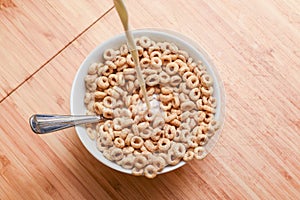 Breakfast cereal bowl with cold milk being poured at the morning breakfast table