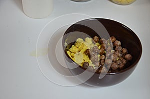 Breakfast cereal, chocolate balls in a brown bowl. Healthy breakfast. Diet Bowl and spoon with corn flakes isolated on