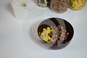 Breakfast cereal, chocolate balls in a brown bowl. Healthy breakfast. Diet Bowl and spoon with corn flakes isolated on