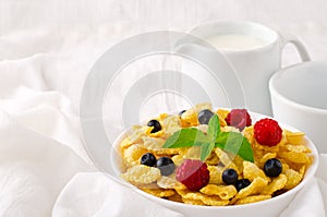 Breakfast with cereal flakes, berries, mint and milk