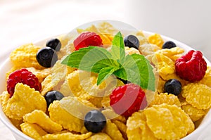 Breakfast with cereal flakes, berries, mint and milk