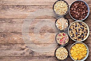 Breakfast cereals in bowls on rustic wooden table, top view