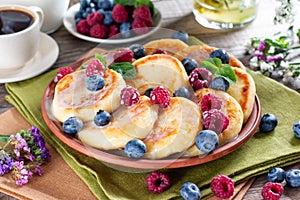 Breakfast with cheesecake, fresh berries . Cottage cheese pancakes or curd fritters. Russian syrniki or sirniki with condensed