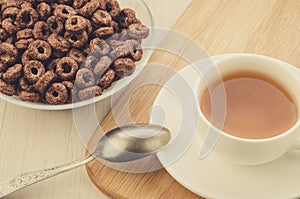 Breakfast with chocolate flakes and a cup of tea/breakfast with chocolate flakes and a cup of tea on a wooden tray. Top view