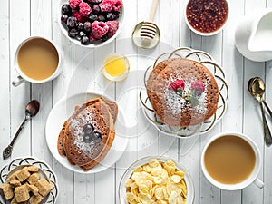 Breakfast chocolate pancakes with berries, a Cup of coffee with cream, honey and cereals. Top view