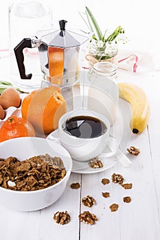 Breakfast with coffee, muesli and fruits over white wooden backg