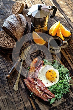 Breakfast with coffee pot fried egg and becon in rustic stile