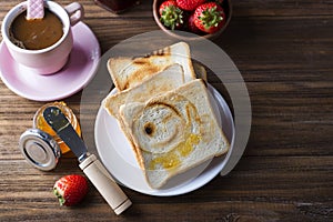 Breakfast with coffee, toasts, strawberry and jam