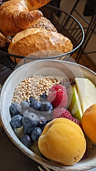 Breakfast consisting of porridge with fruits and berries and different types of bread