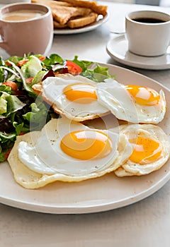 Breakfast containing fried eggs, salat, pancakes, and coffee. Image generated by AI.