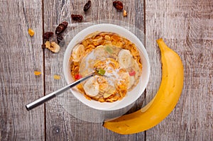 Breakfast, corn flakes with a spoon, raisins, bananas on burlap.