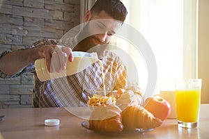 Breakfast with cornflakes, milk and croissant
