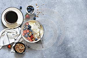 Breakfast - cottage cheese with berries and a cup of coffee, top view. Granola with nuts, honey and strawberries